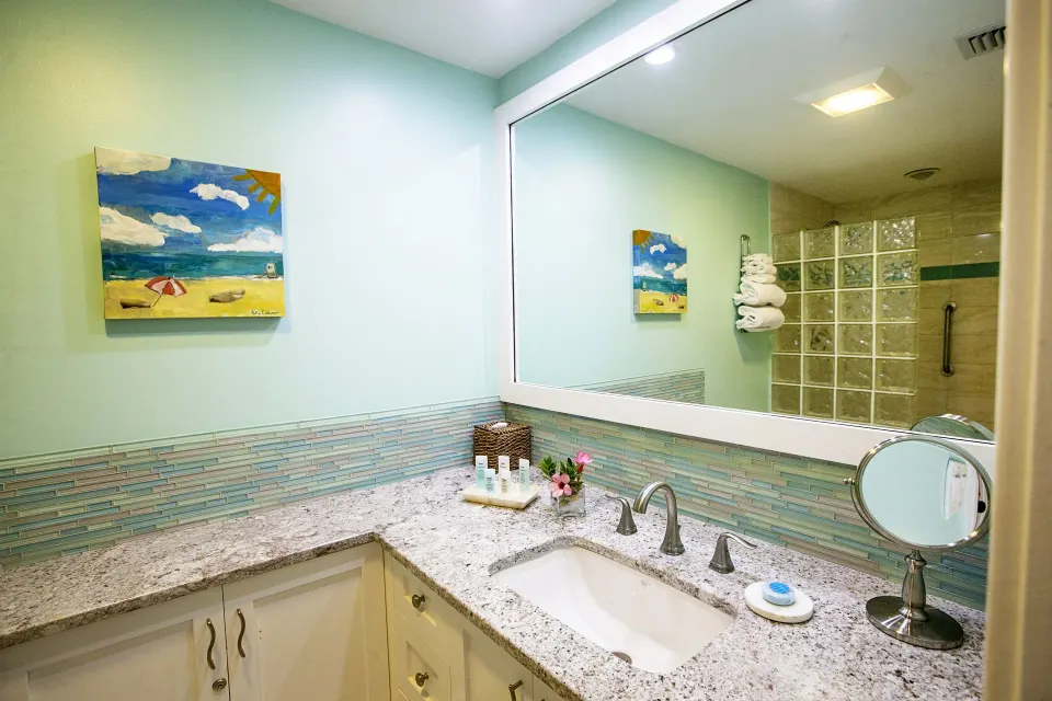 Granite vanity and shower area in a Deluxe Two Bedroom Suite bathroom at Ocean Club West, Grace Bay Beach.