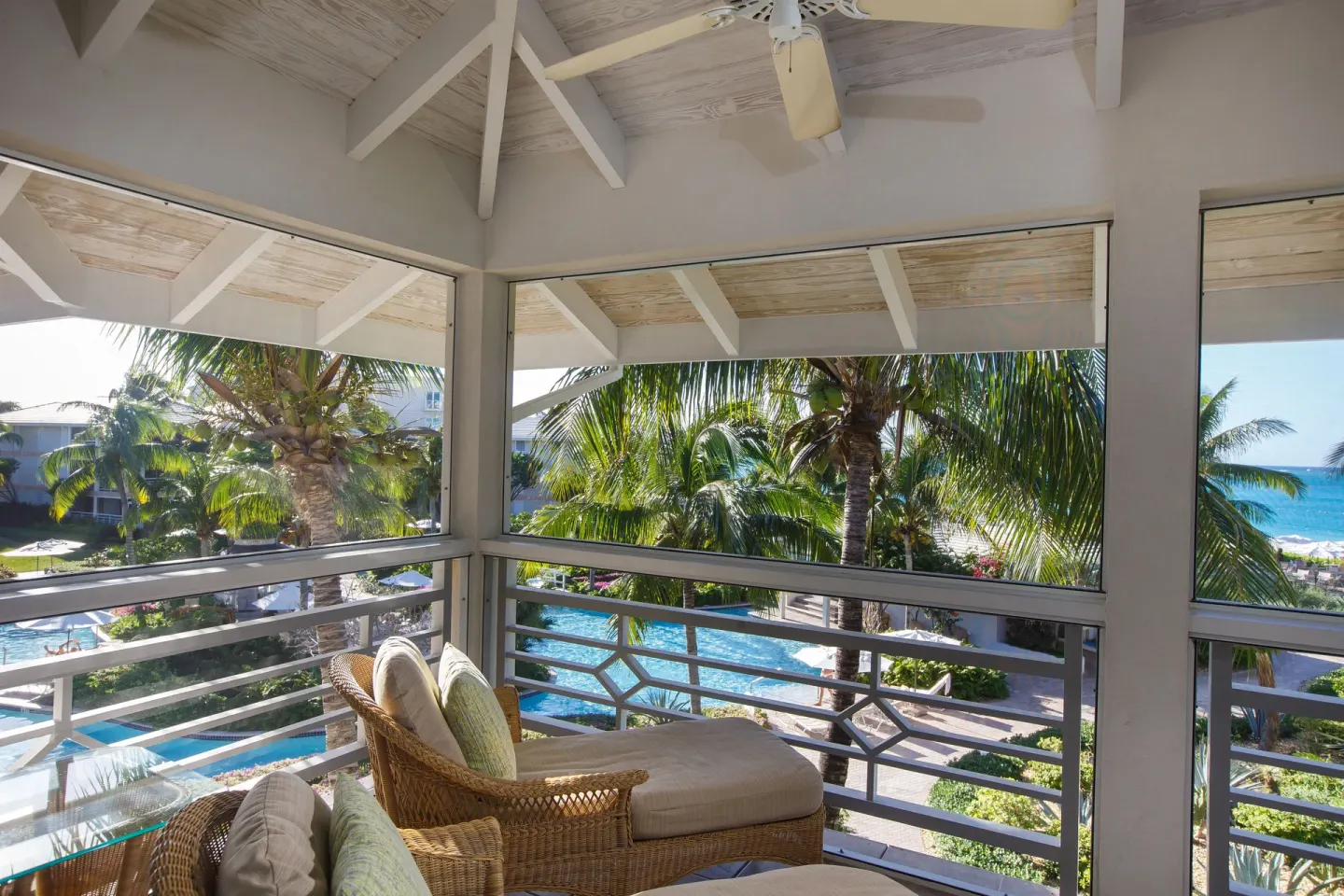 Deluxe Two Bedroom Suite balcony lounge with ocean glimpse at Ocean Club West, Grace Bay Beach.