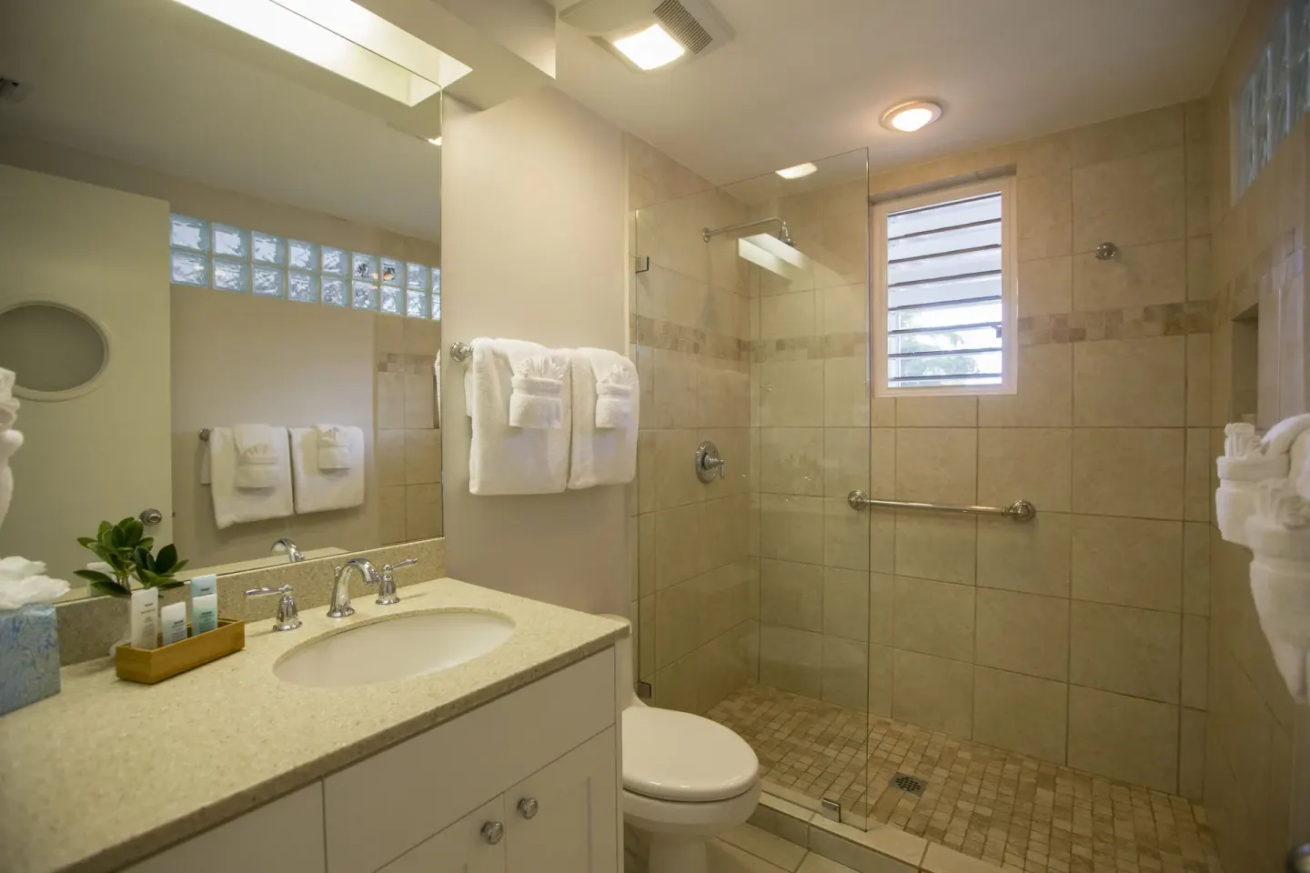 Studio suite bathroom with vanity and glass shower at Ocean Club West, Grace Bay Beach.