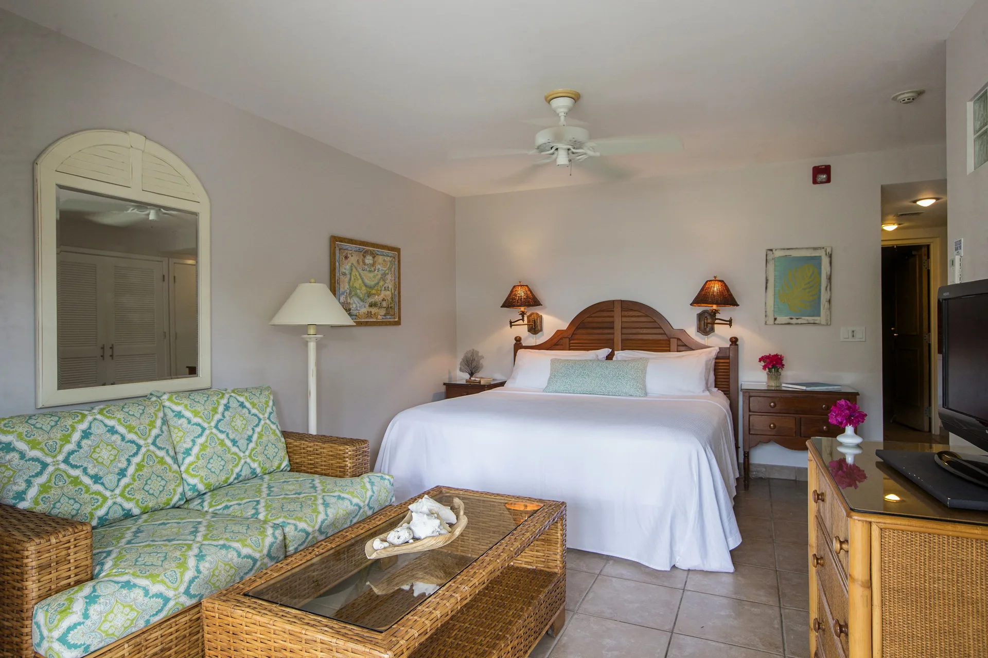 Studio suite with king bed and wicker seating at Ocean Club West, Grace Bay Beach.