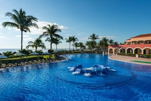 Large oceanfront pool with palm trees at Ocean Coral and Turquesa.