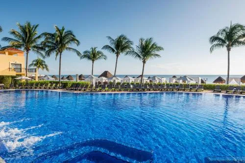 Pool edge with palms, loungers, and ocean views at Ocean Coral and Turquesa.
