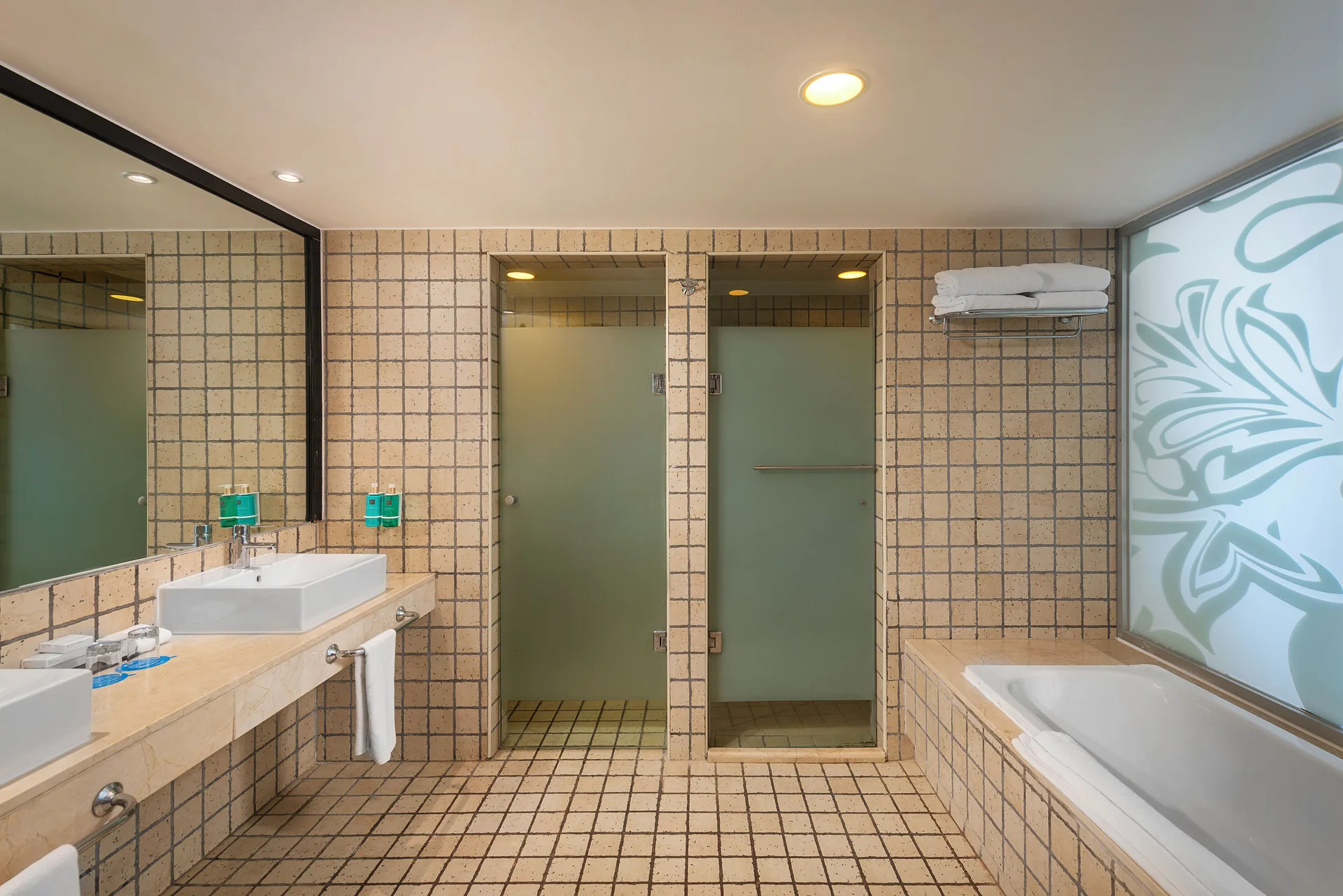 Honeymoon Suite bathroom with tub, showers, and vanity at Ocean Coral and Turquesa.