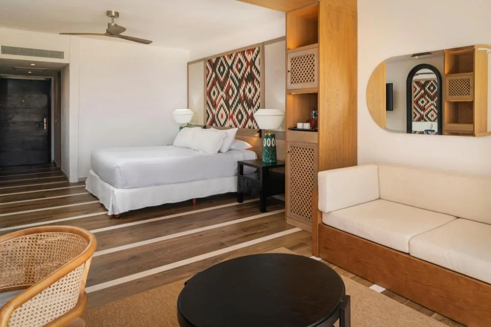 Junior Suite Elegance Nature View bed and sitting area at Ocean Coral and Turquesa.