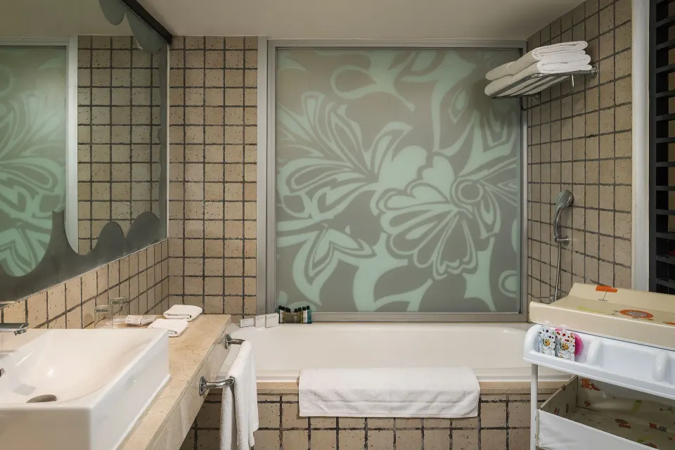 Junior Suite Waterpark Side bathroom with tub and frosted floral window at Ocean Coral and Turquesa.