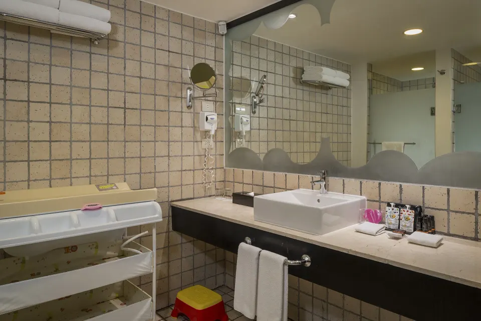 Junior Suite Waterpark Side bathroom with vanity and baby changing station at Ocean Coral and Turquesa.