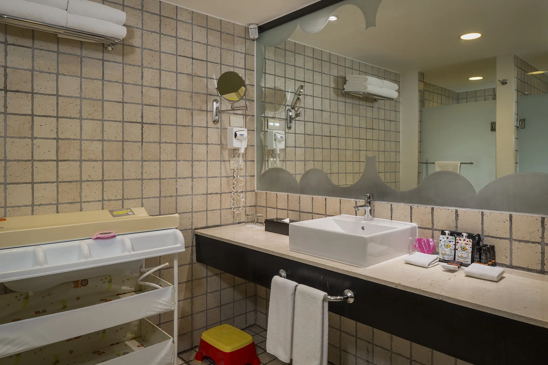 Junior Suite Waterpark Side bathroom with vanity and baby changing station at Ocean Coral and Turquesa.