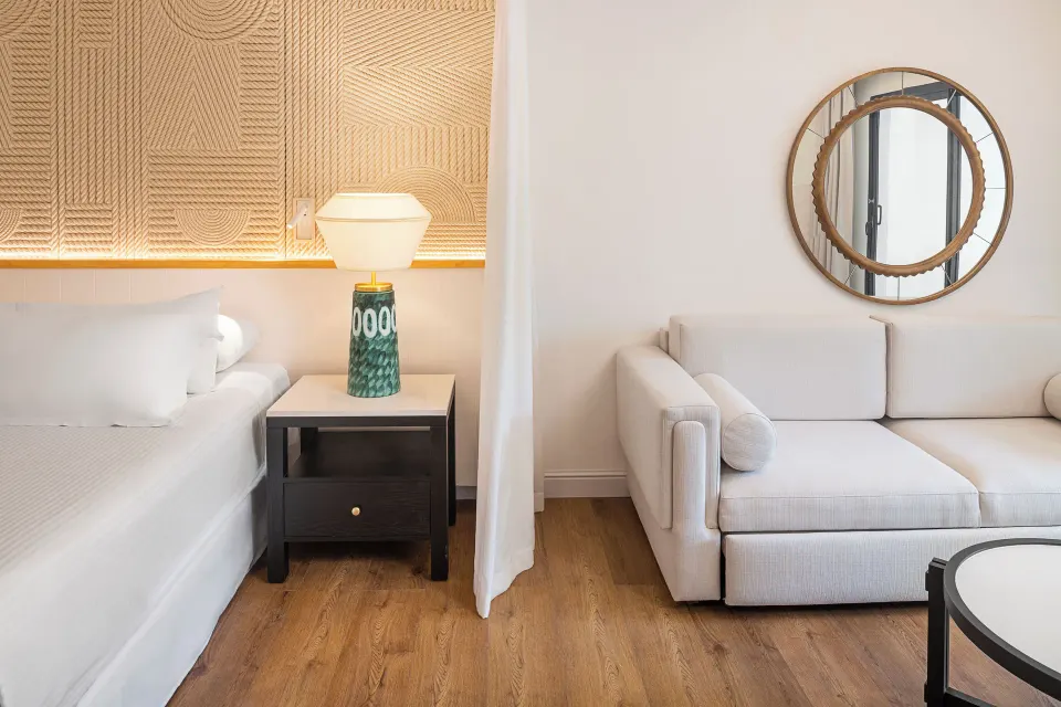 Junior Suite Waterpark Side king bed beside sofa seating at Ocean Coral and Turquesa.