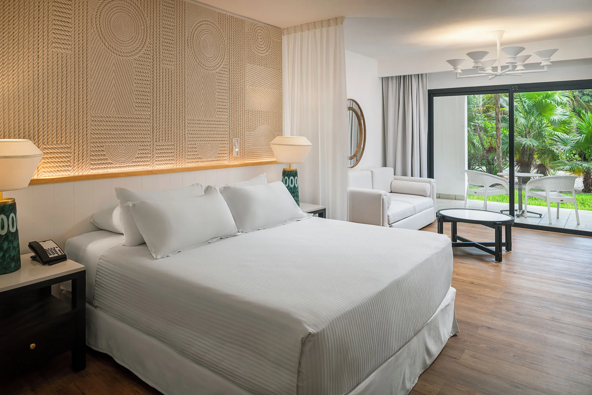 Junior Suite Waterpark Side king bed and sitting area at Ocean Coral and Turquesa.