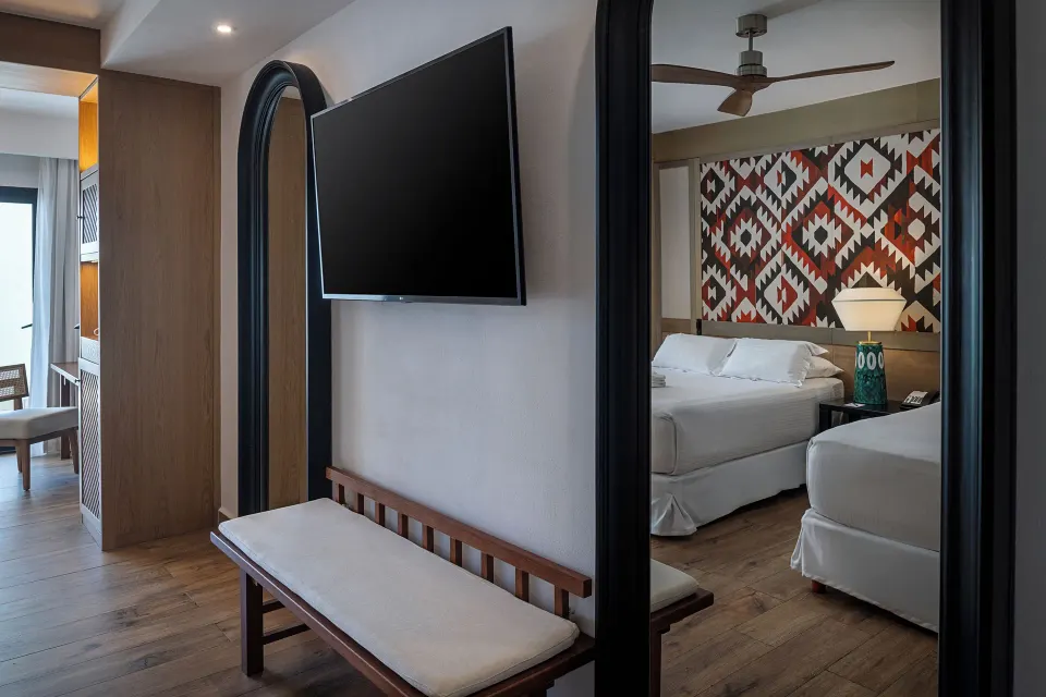 Privilege Junior Suite entry with TV, bench, and bed area at Ocean Coral and Turquesa.