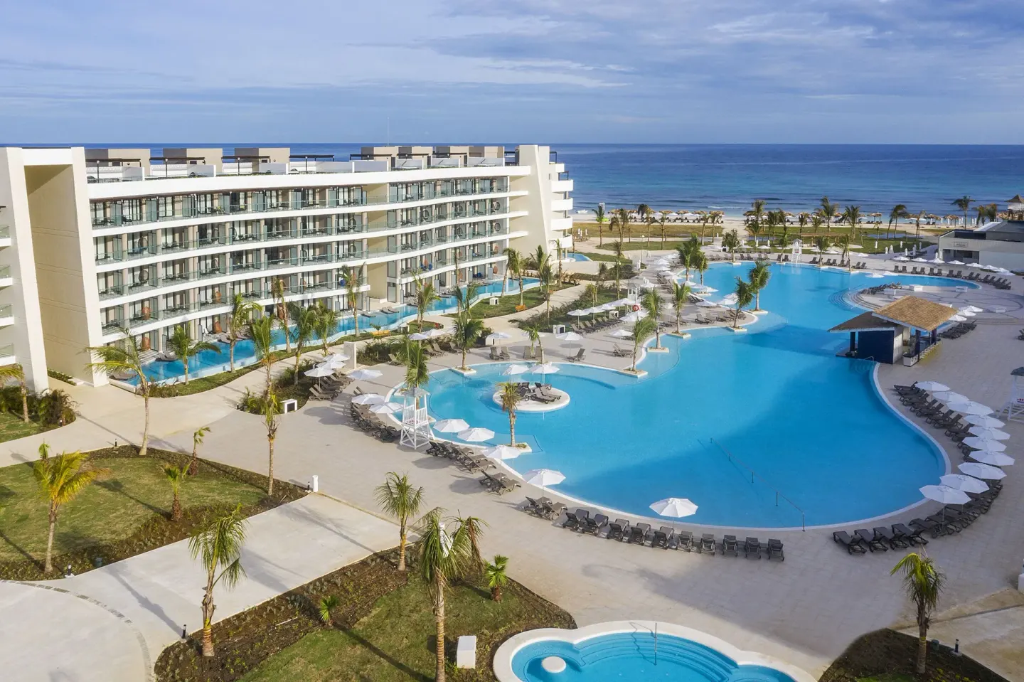 Aerial view of the main pool complex and beachfront resort buildings at Ocean Coral Spring.
