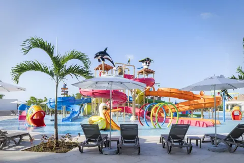 Children's water park with colorful slides and loungers at Ocean Coral Spring.