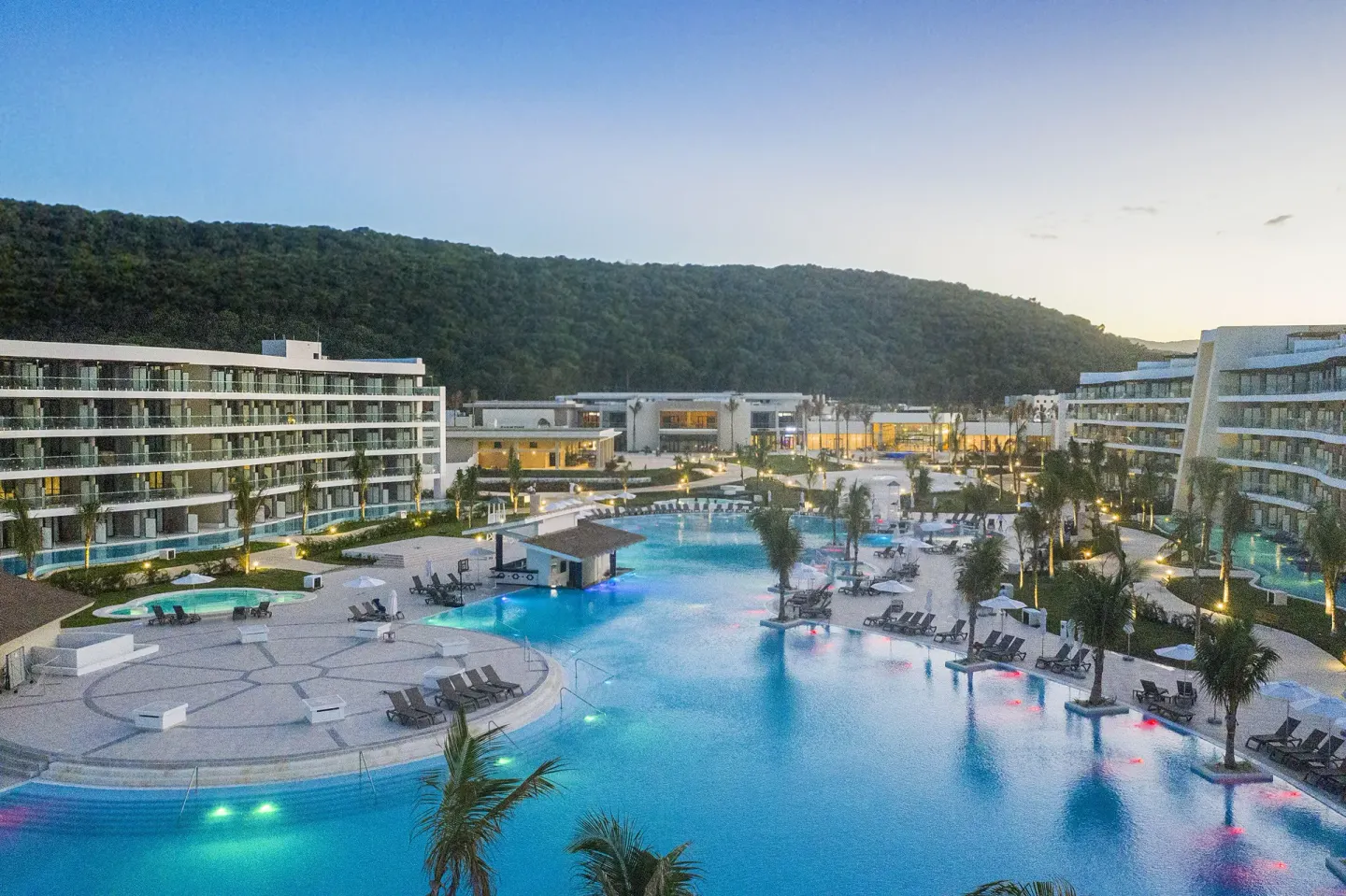 Evening view of the illuminated pool complex at Ocean Coral Spring.