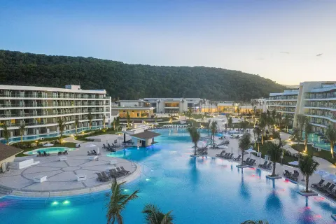 Evening view of the illuminated pool complex at Ocean Coral Spring.