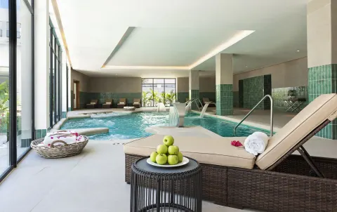 Indoor spa pool with loungers, towels and green apples at Ocean Coral Spring.