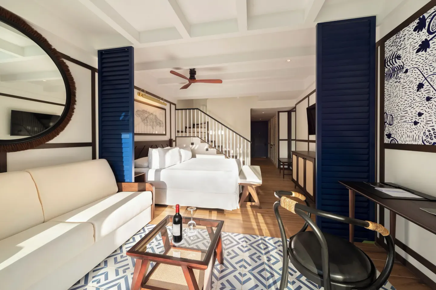 Loft-style guest suite with sofa, bed, stairs, and desk at Ocean Coral Spring.