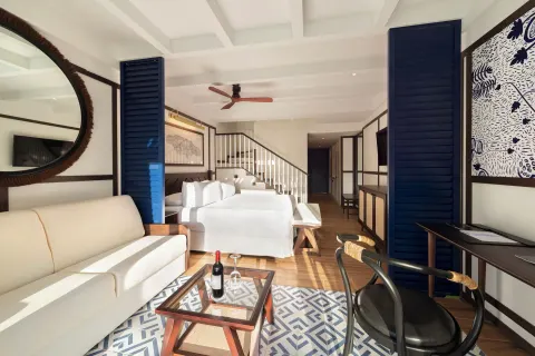Loft-style guest suite with sofa, bed, stairs, and desk at Ocean Coral Spring.