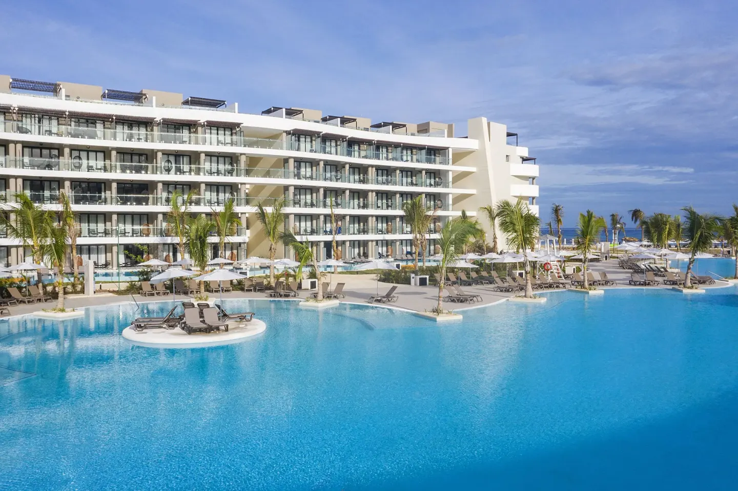 Large pool with loungers and resort buildings at Ocean Coral Spring.