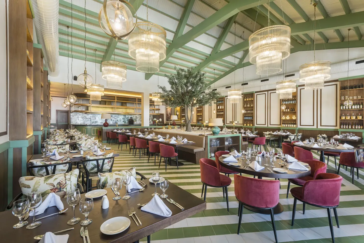 Elegant restaurant with green beams, chandeliers and set tables at Ocean Coral Spring.