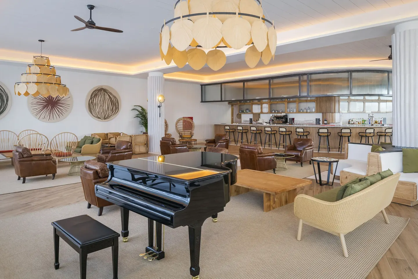 Piano lounge with a bar, leather chairs, and large pendant lights at Ocean Coral Spring.