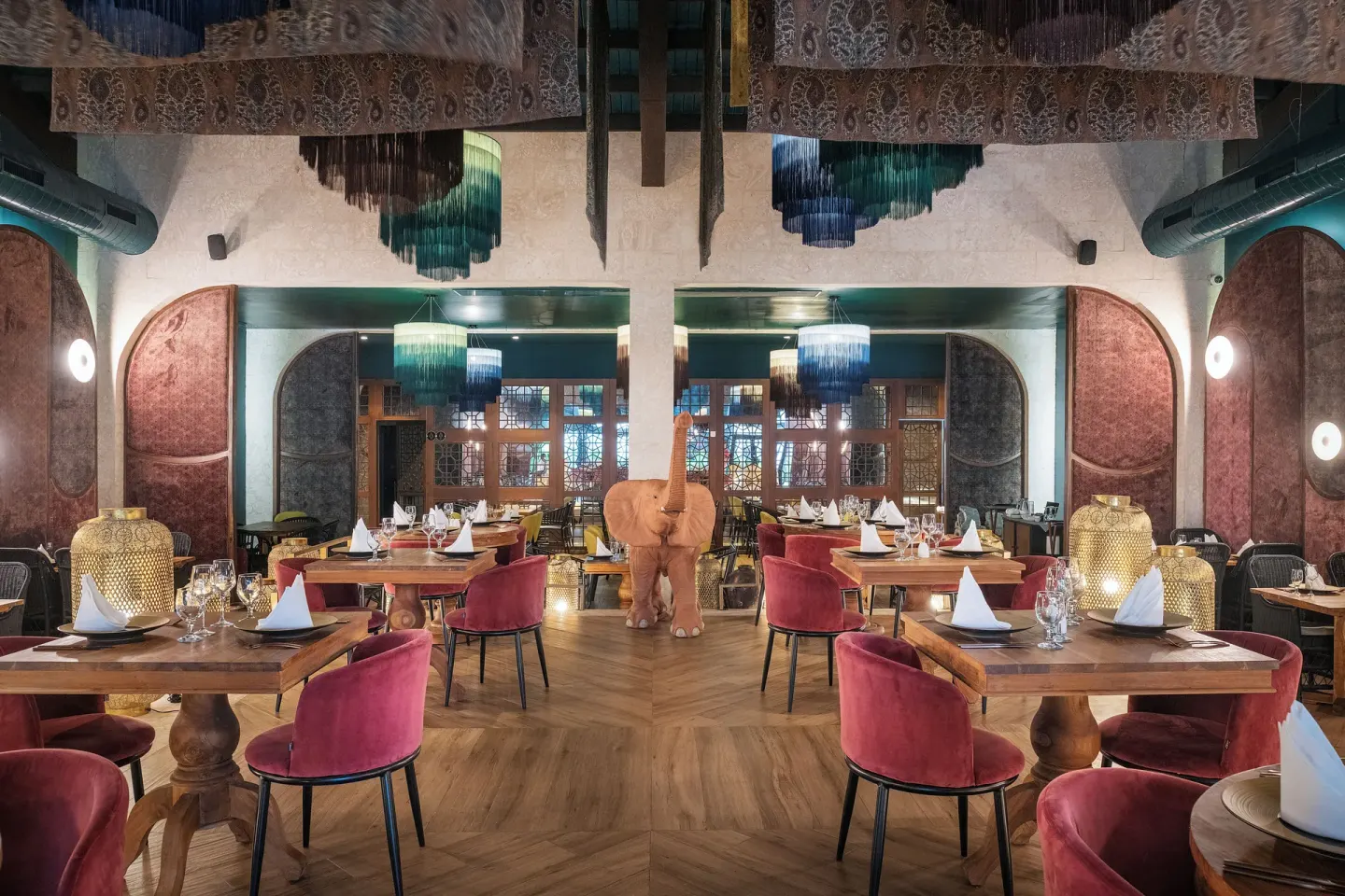 Indian-inspired restaurant with elephant sculpture and red chairs at Ocean Coral Spring.