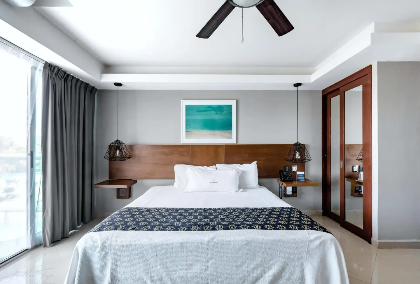 King bed centered between pendant lights at Ocean Dream Cancun.