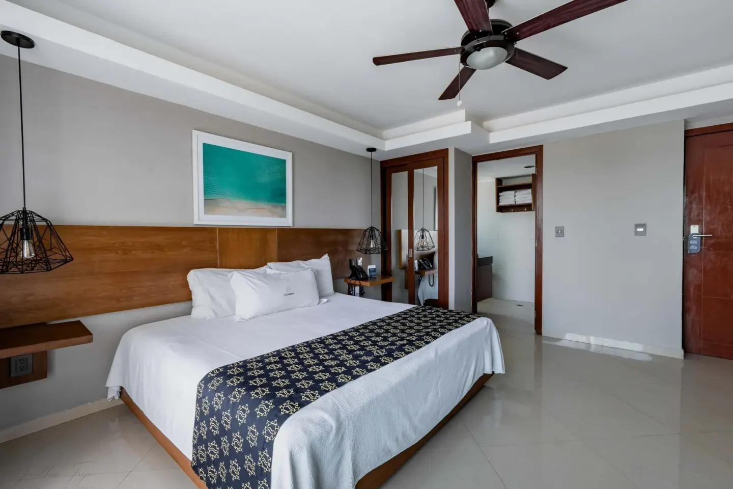 King bed guest room with mirrored closet doors at Ocean Dream Cancun.