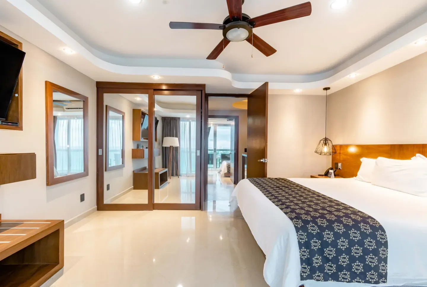Guest room with king bed and mirrored closet doors at Ocean Dream Cancun.