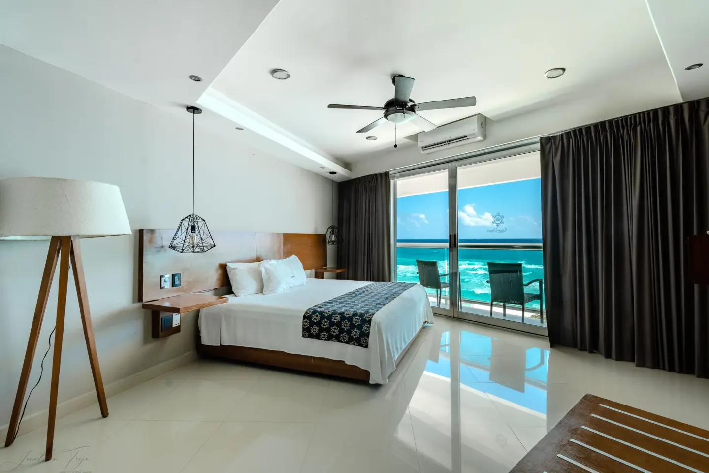 King-bed guest room with balcony doors and ocean view at Ocean Dream Cancun.