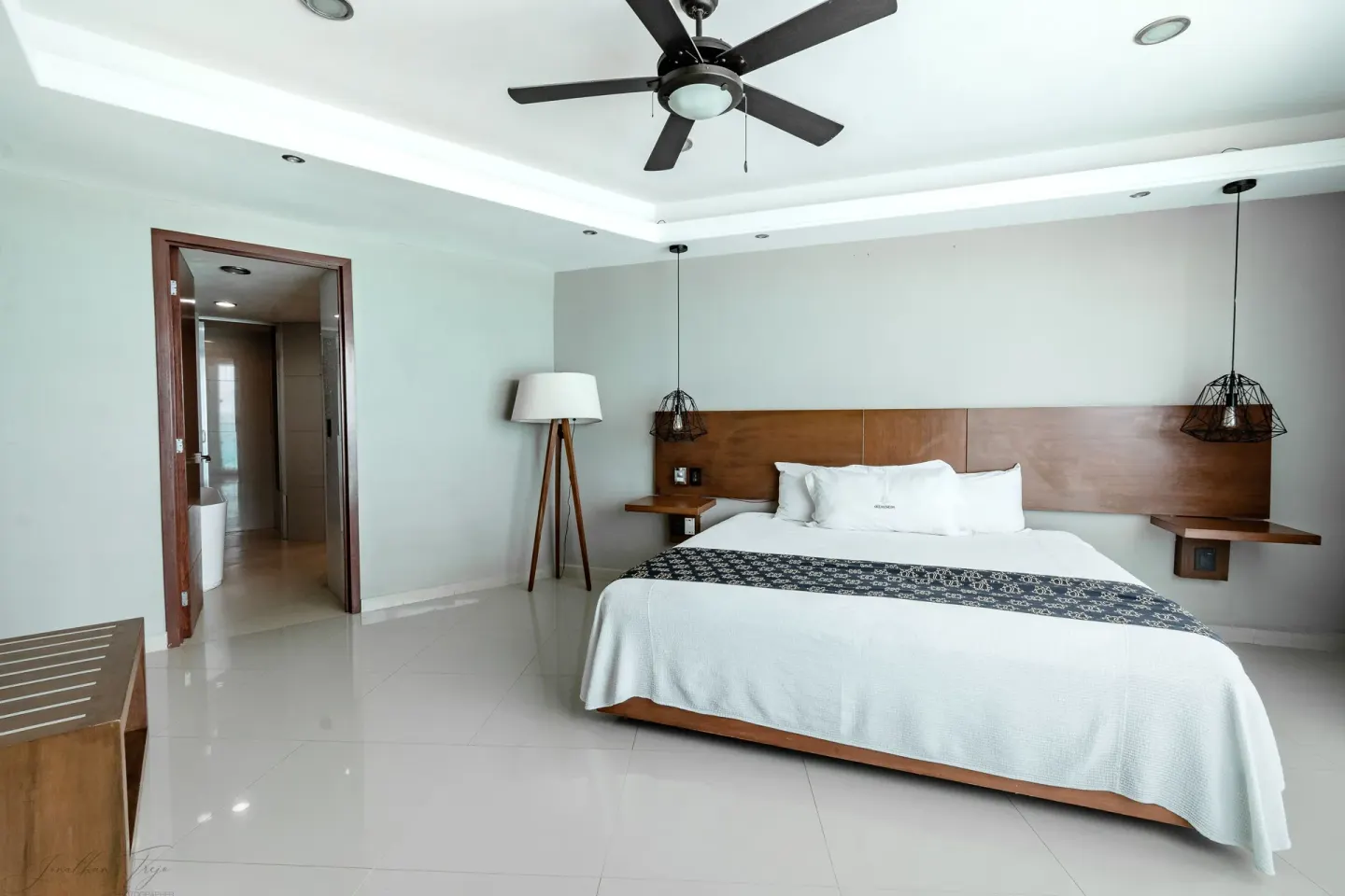 King bed guest room with open bathroom doorway at Ocean Dream Cancun.
