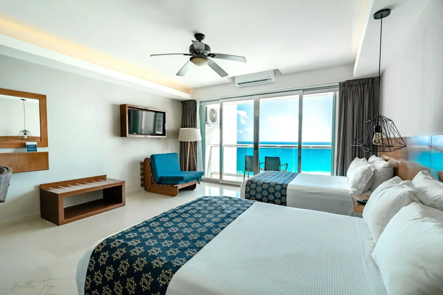 Guest room with two beds, balcony, and turquoise ocean view at Ocean Dream Cancun.