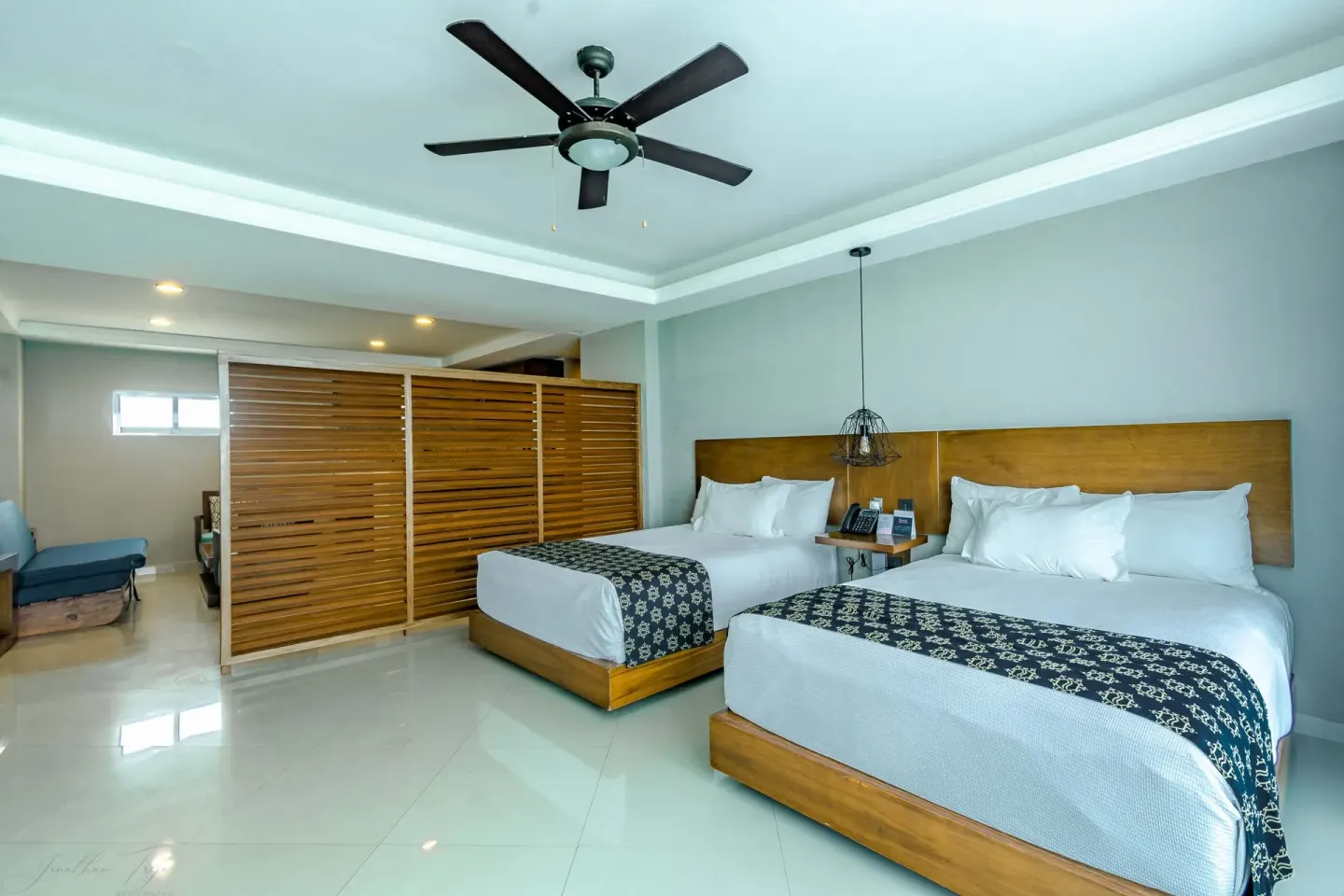 Two-bed guest room with slatted divider and lounge area at Ocean Dream Cancun.