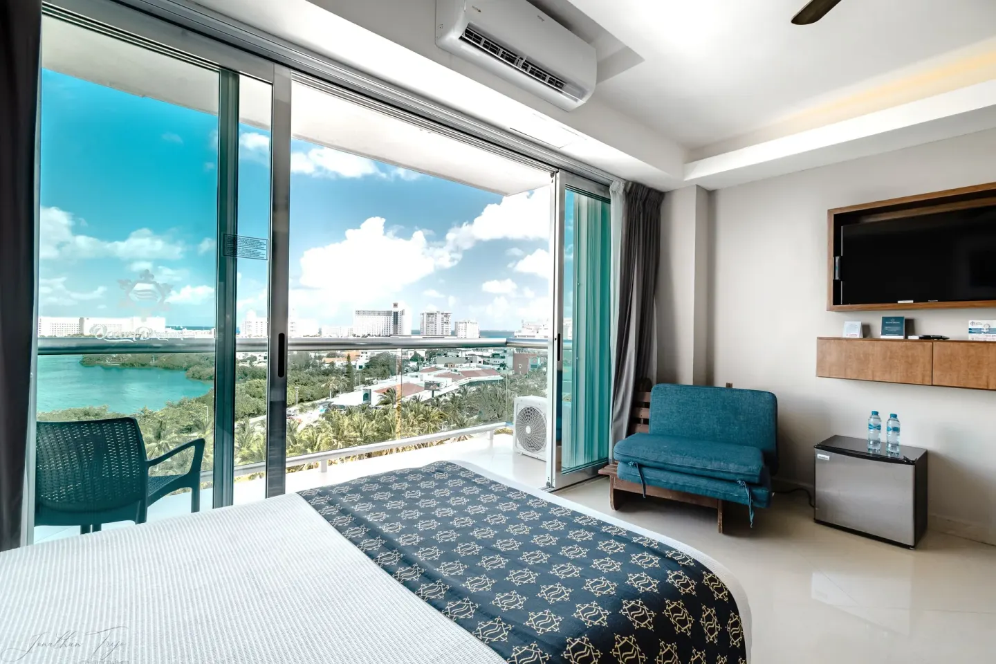 Guest room with bed, sofa, balcony, and lagoon view at Ocean Dream Cancun.