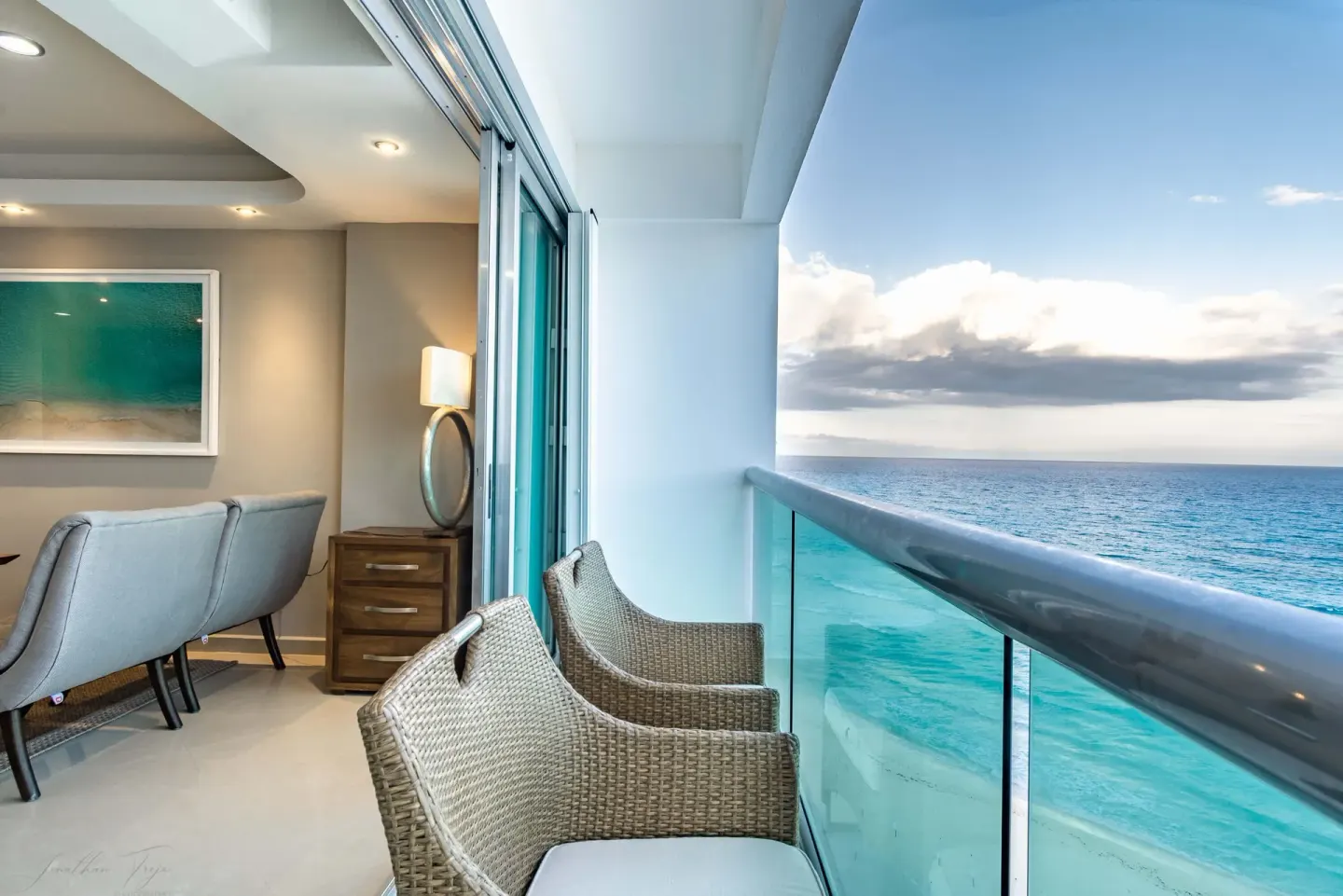 Oceanfront balcony with woven chairs at Ocean Dream Cancun.