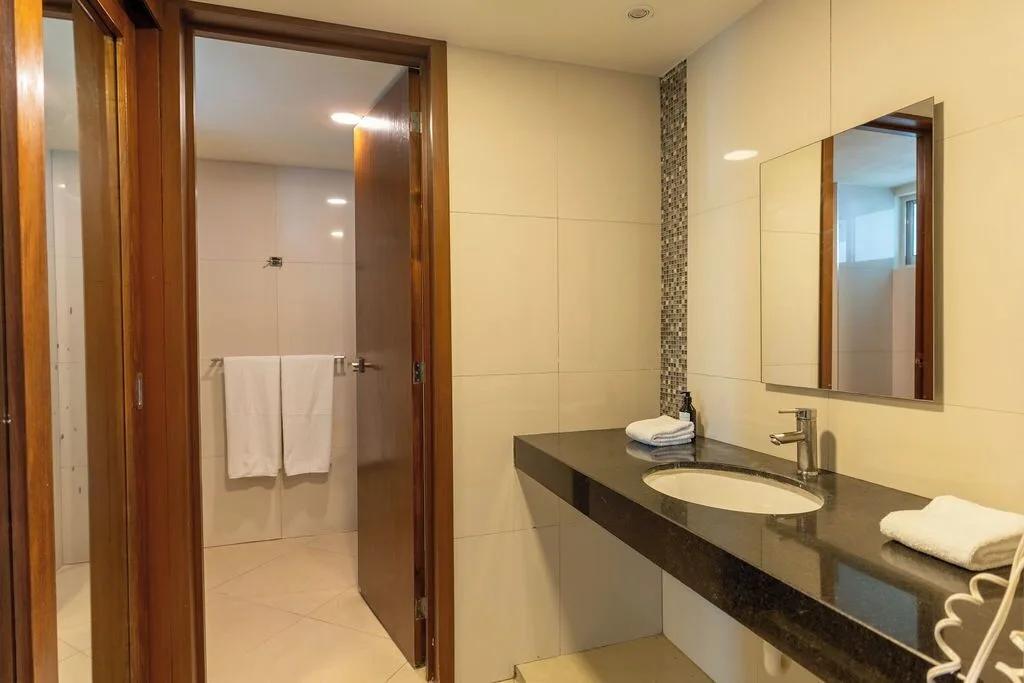 Deluxe room bathroom vanity with sink, mirror, and towels at Ocean Dream Cancun.