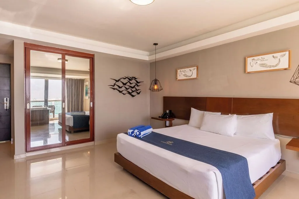 Deluxe room king bed with mirrored closet doors at Ocean Dream Cancun.