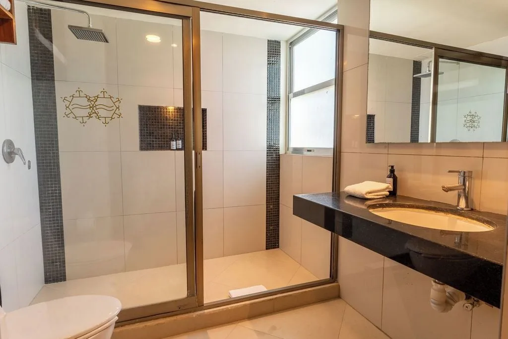 Deluxe Room Ocean Dream Cancun bathroom with walk-in shower and sink vanity at Ocean Dream Cancun.