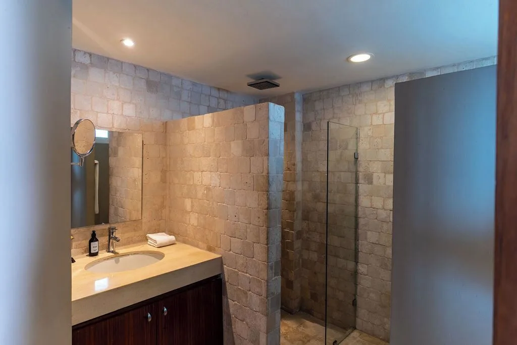 Diamond Suite bathroom with stone-tile shower and vanity at Ocean Dream Cancun.