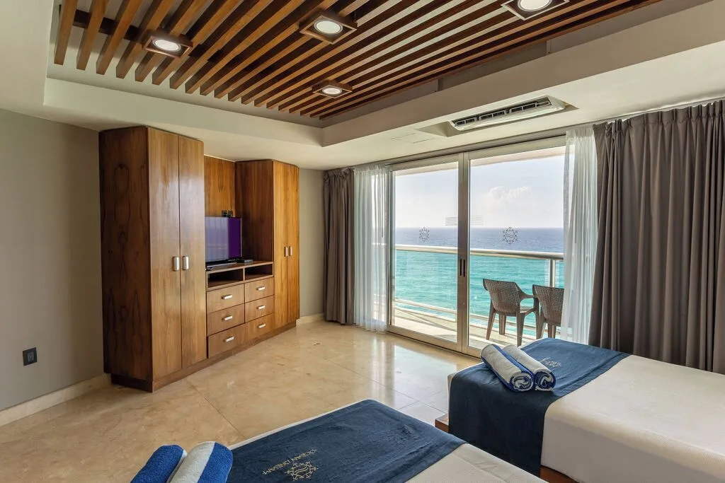 Diamond Suite bedroom with two beds, balcony, and ocean view at Ocean Dream Cancun.