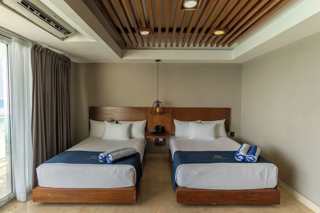 Diamond Suite two-bed room with blue runners and wood-slat ceiling at Ocean Dream Cancun.