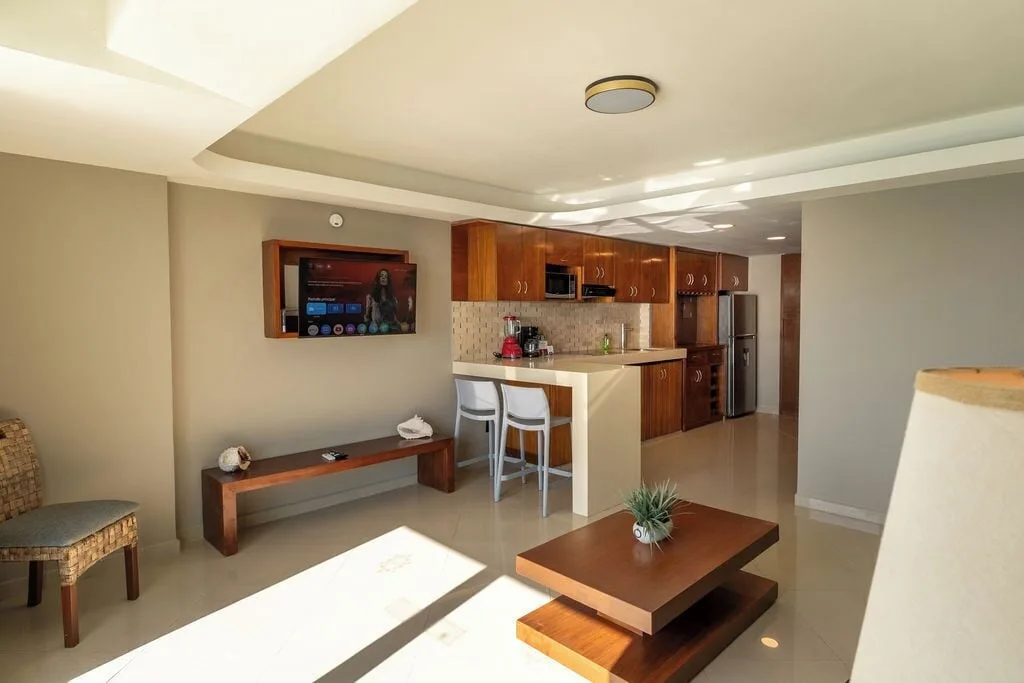 Penthouse living room and kitchenette with TV at Ocean Dream Cancun.