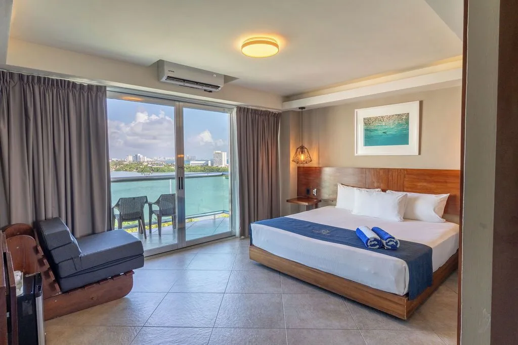 Standard Room with king bed, sofa and lagoon-view balcony at Ocean Dream Cancun.