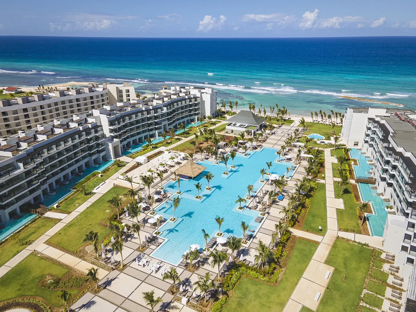 Aerial view of the pools, resort buildings, and oceanfront at Ocean Eden Bay.