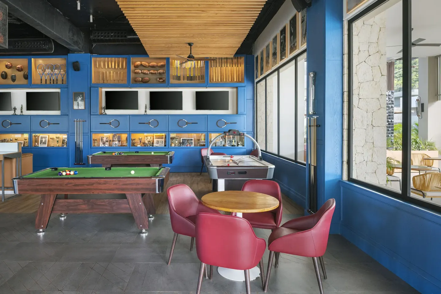 Game room with pool tables, air hockey, and red chairs at Ocean Eden Bay.
