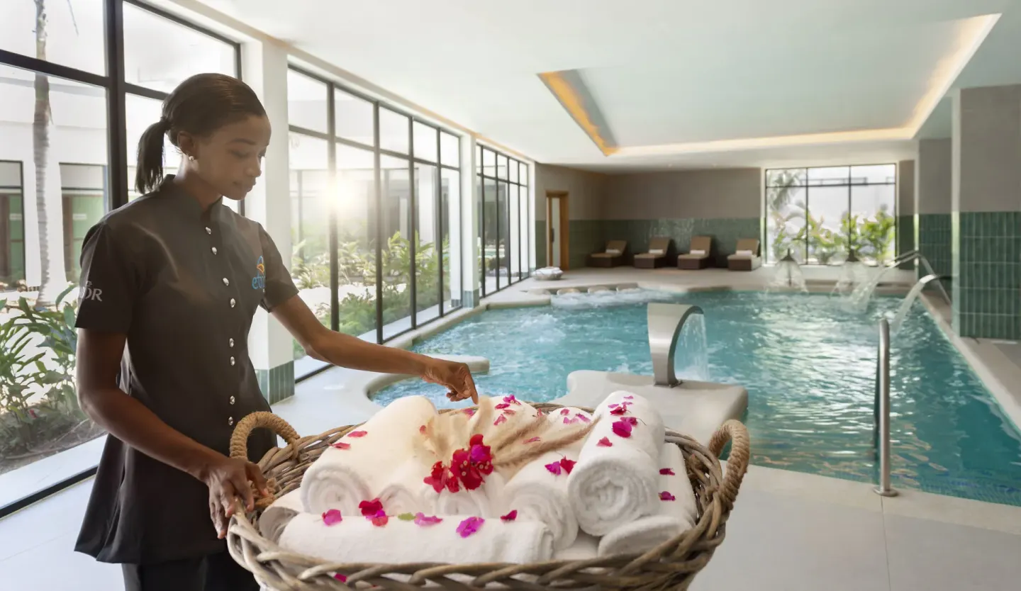 Indoor spa pool with towels and flower petals beside an attendant at Ocean Eden Bay.