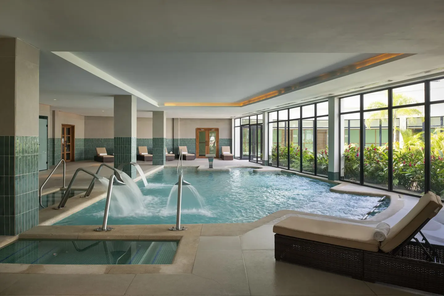 Indoor spa pool with water features and lounge chairs at Ocean Eden Bay.