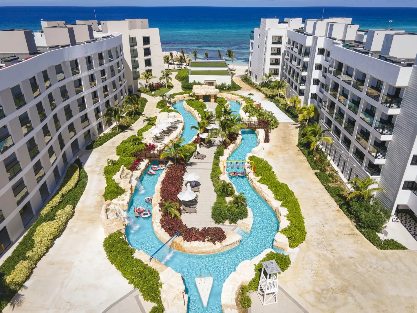 Aerial view of lazy river between guest buildings and the ocean at Ocean Eden Bay.