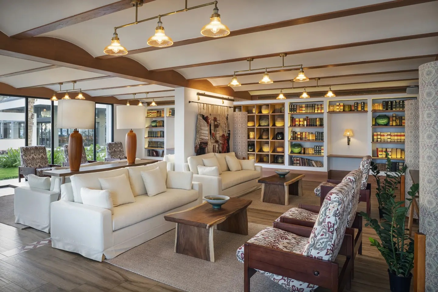 Resort lounge with white sofas, patterned chairs, and display shelves at Ocean Eden Bay.
