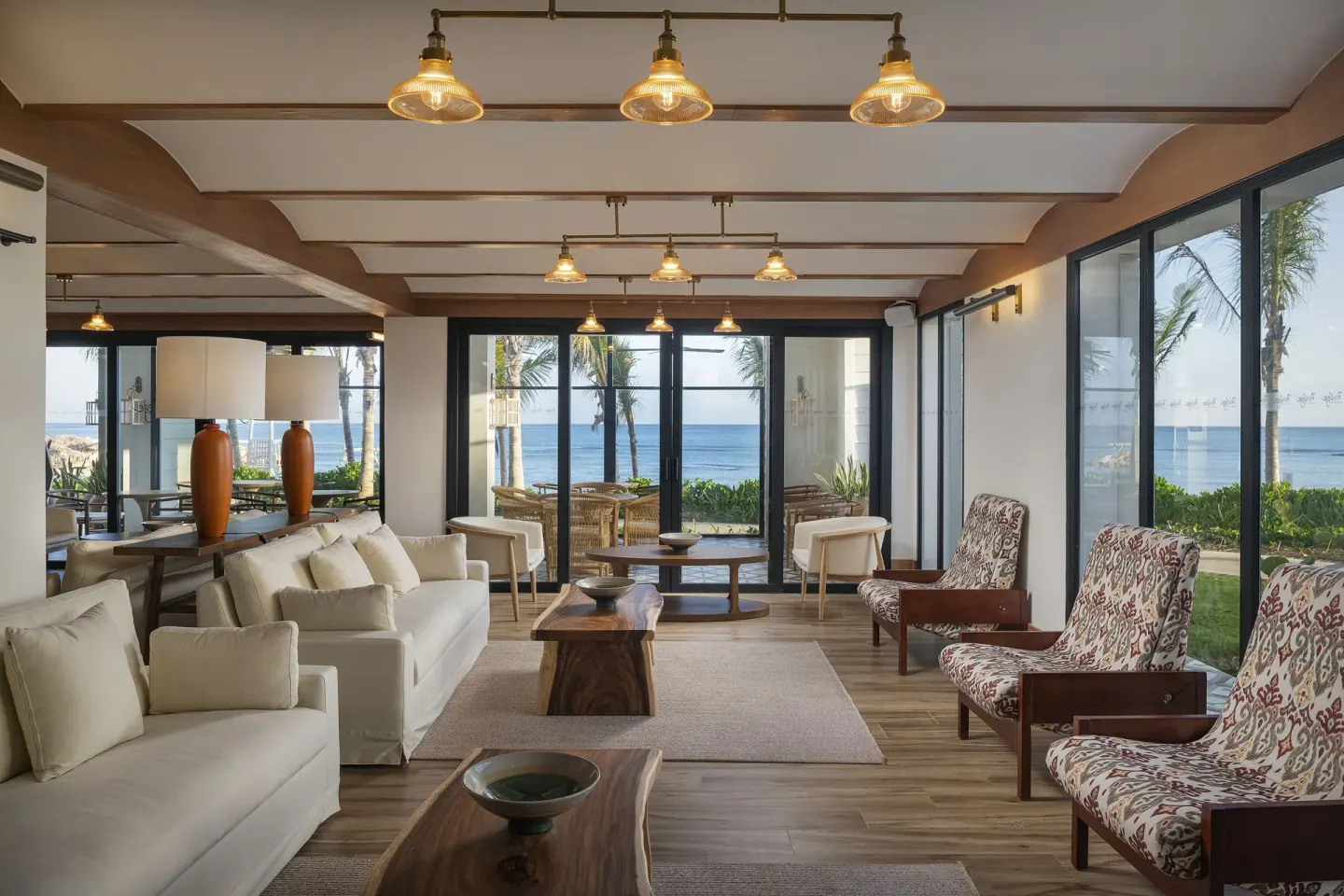 Ocean-view lounge seating area with sofas and patterned chairs at Ocean Eden Bay.