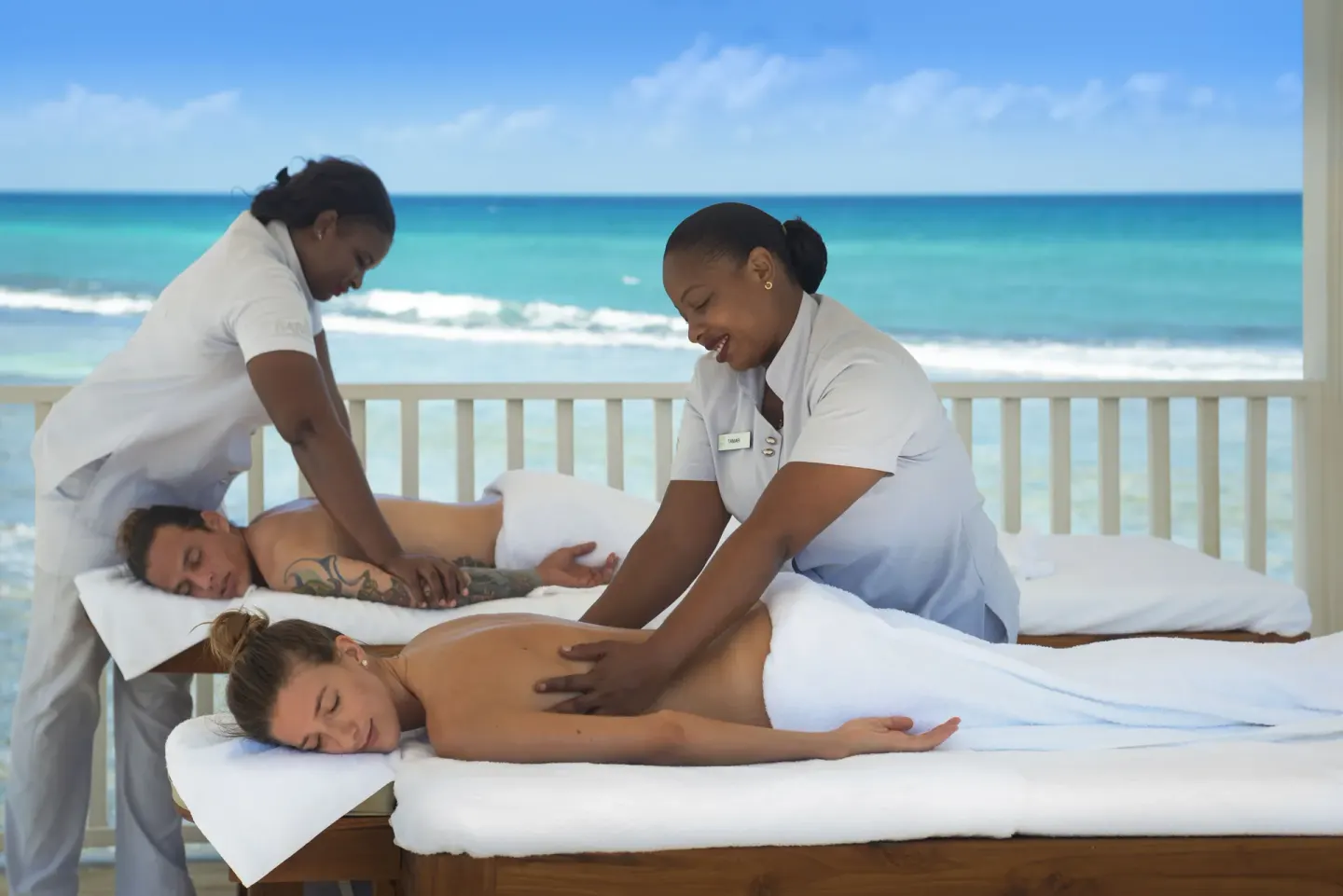 Two guests receive seaside massages from spa therapists at Ocean Eden Bay.